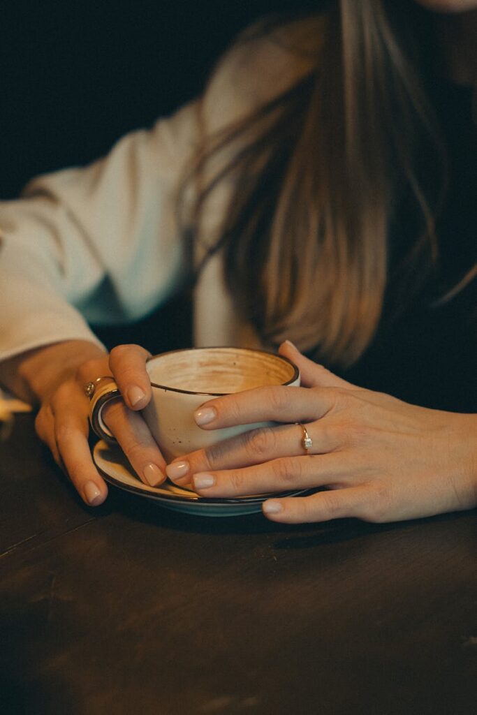 close up of woman sitting at cafe table with coffee cup