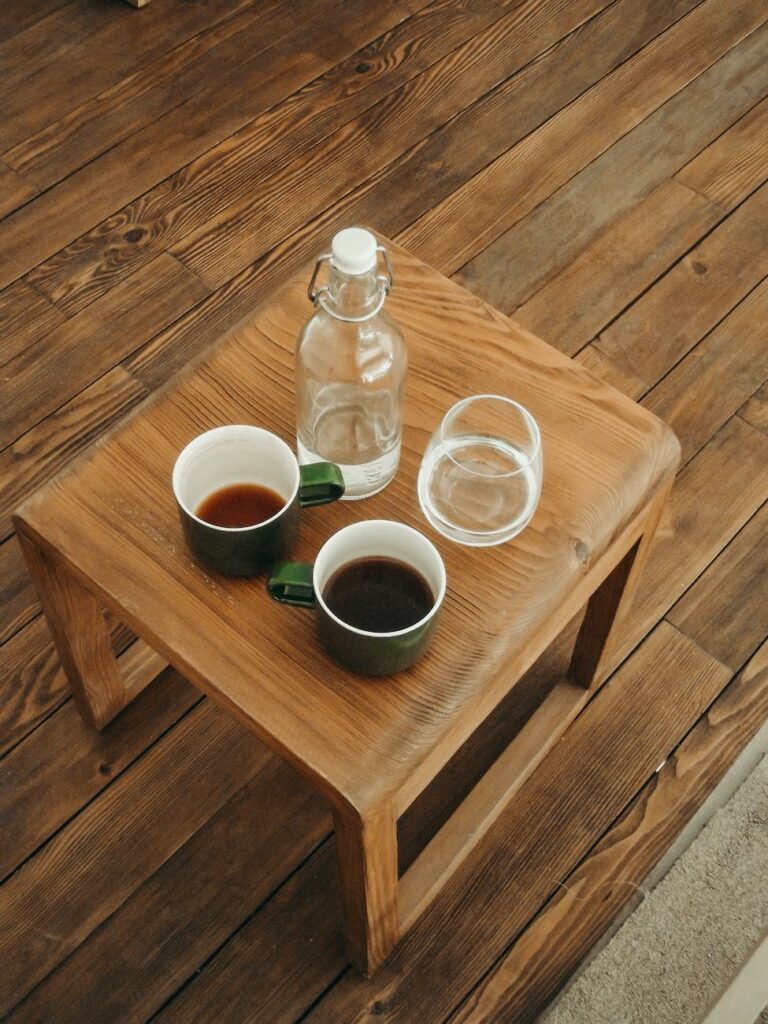 coffee in cups and water on wooden table