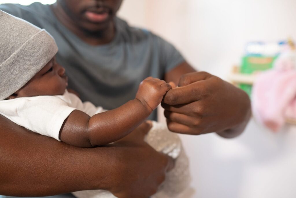 shallow focus photo of man carrying his baby