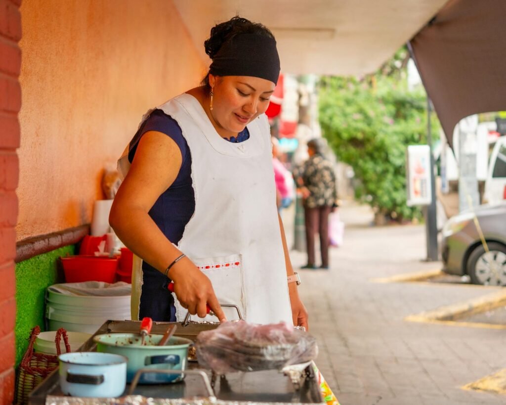 a woman in an apron cooking food on a grill